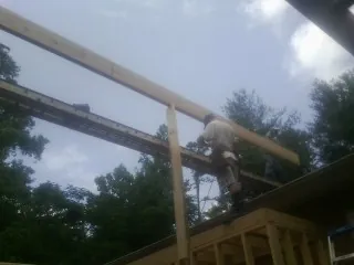 Carpenter setting a ridge beam over a new addition frame — Ice Dam Removal by Roofing Brothers in Frankfort